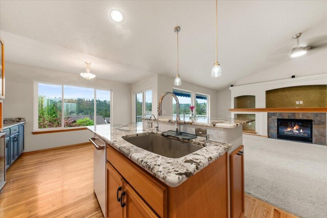711 W Bolan Ave, Spokane, WA 99224 - kitchen with a sink, open floor plan, a tile fireplace, vaulted ceiling, and light stone counters