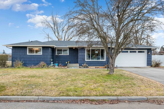 ranch-style house with a garage, fence, concrete driveway, roof with shingles, and a front yard