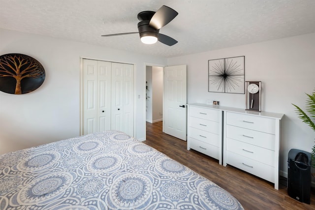 bedroom with a textured ceiling, dark wood-type flooring, a ceiling fan, baseboards, and a closet