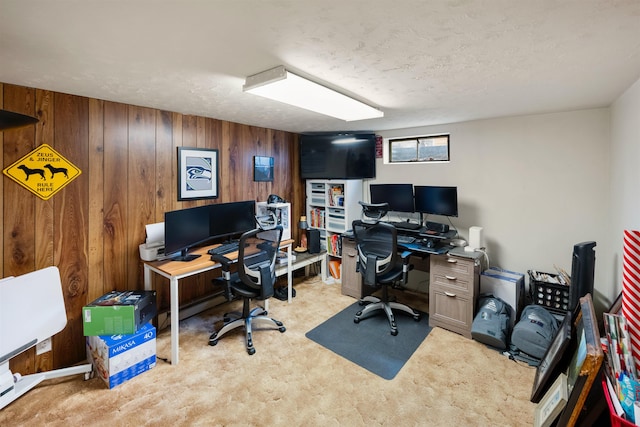 office area featuring carpet flooring, wood walls, and a textured ceiling