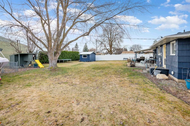 view of yard with a storage shed, a patio, a trampoline, an outdoor structure, and a playground