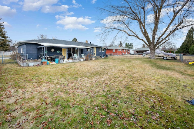 back of property with a lawn, a chimney, and fence