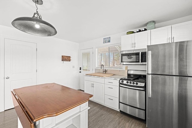 kitchen featuring a sink, appliances with stainless steel finishes, white cabinets, and dark wood finished floors