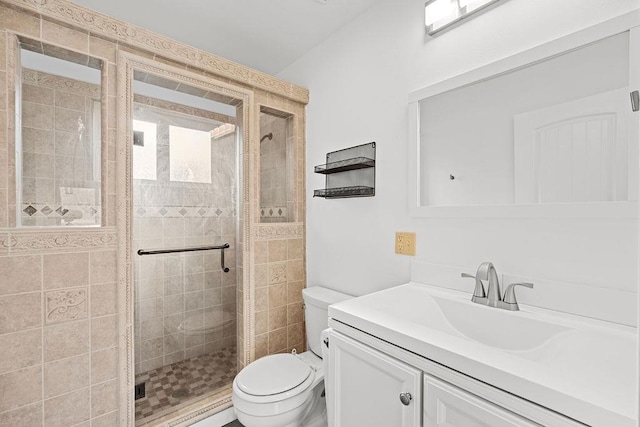 bathroom featuring a stall shower, vanity, and toilet