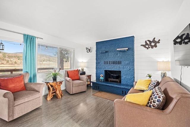 living room with a large fireplace and wood finished floors