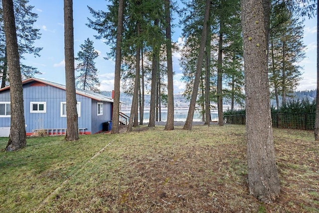 view of yard featuring a water view and fence