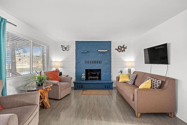 living area featuring a brick fireplace and wood finished floors