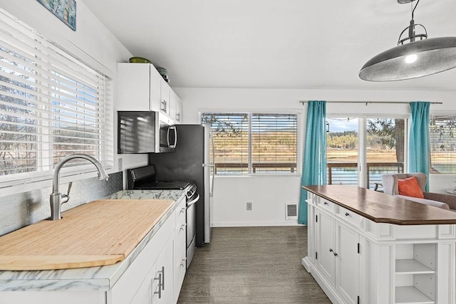 kitchen featuring white cabinetry, visible vents, stainless steel appliances, and dark wood-style flooring