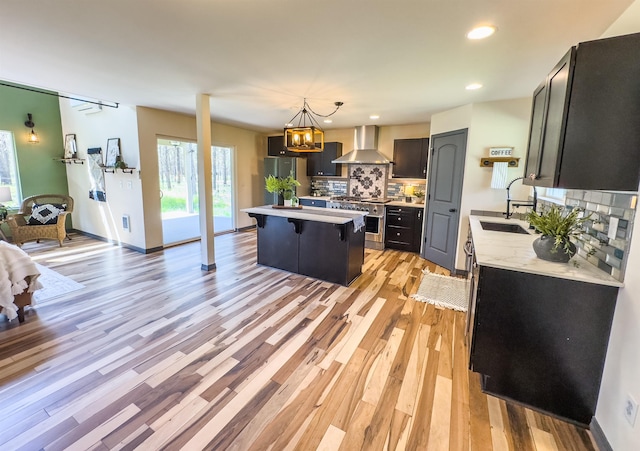 22410 S Ritchey Rd, Cheney, WA 99004 - kitchen with wall chimney range hood, appliances with stainless steel finishes, a sink, light countertops, and a kitchen island