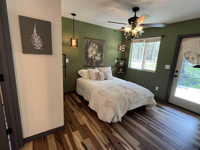 bedroom with baseboards, ceiling fan, wood finished floors, and multiple windows