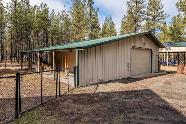 detached garage featuring fence and driveway
