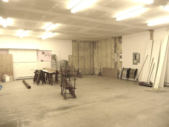 basement featuring a baseboard radiator and electric panel