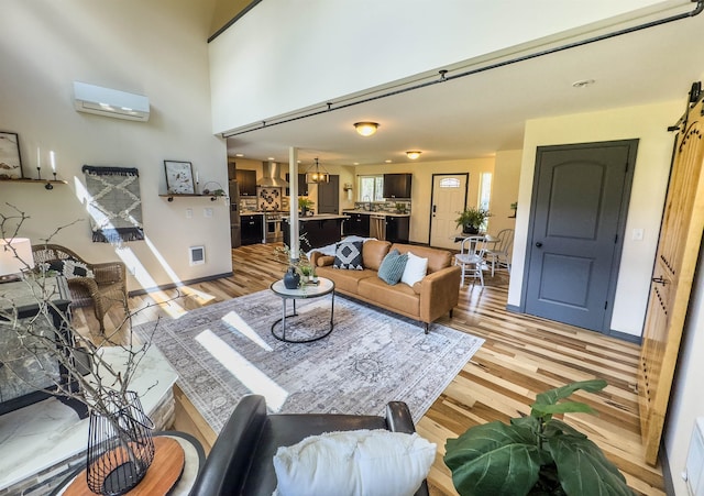 22410 S Ritchey Rd, Cheney, WA 99004 - living room with wood finished floors, an AC wall unit, and baseboards