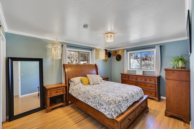 bedroom with baseboards, a textured ceiling, light wood-style flooring, and crown molding