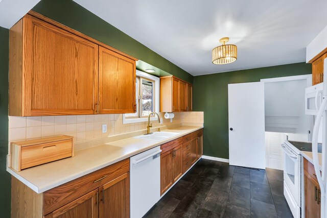 kitchen featuring white appliances, brown cabinetry, decorative backsplash, light countertops, and a sink