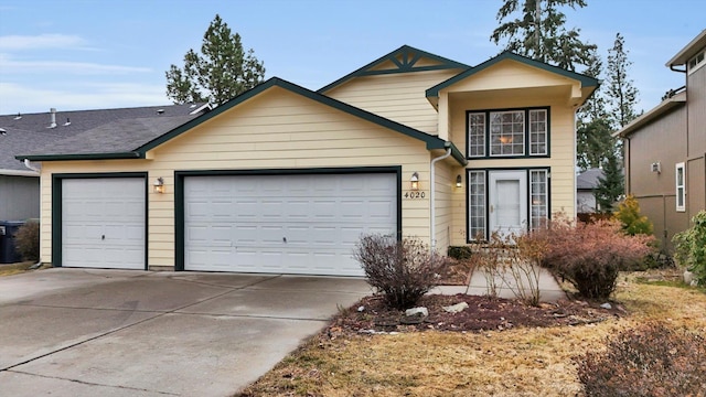 view of front of house featuring driveway, a shingled roof, and an attached garage