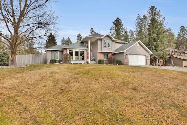 view of front of home featuring driveway, an attached garage, fence, a front lawn, and brick siding