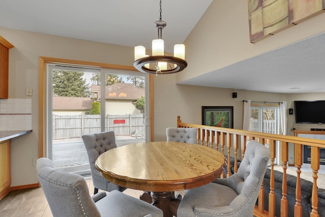 dining room featuring a chandelier, baseboards, and light wood-style floors