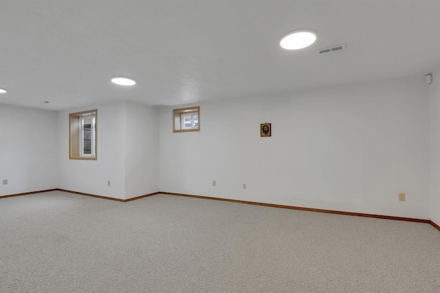 below grade area featuring carpet flooring, visible vents, and baseboards