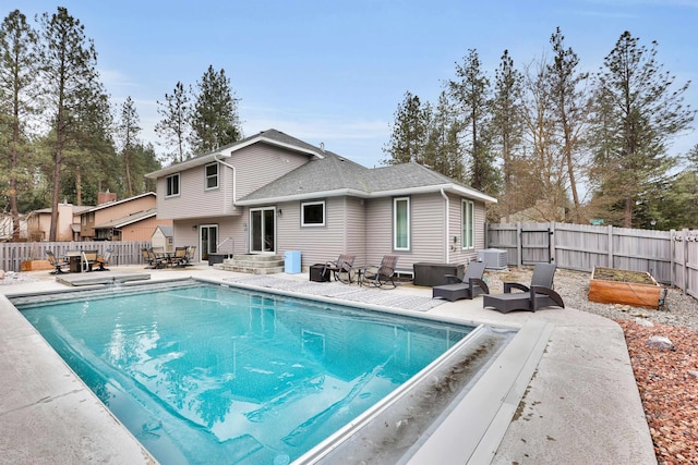 view of pool featuring entry steps, a patio, a fenced backyard, and a garden