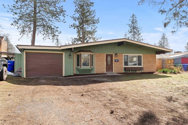 single story home featuring driveway, an attached garage, fence, and brick siding