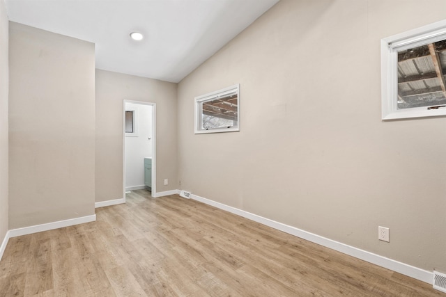 unfurnished room featuring light wood-style flooring, visible vents, and baseboards