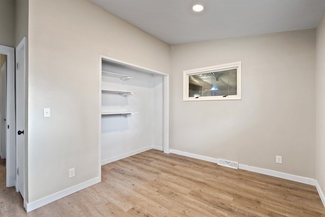 unfurnished room featuring visible vents, baseboards, and wood finished floors