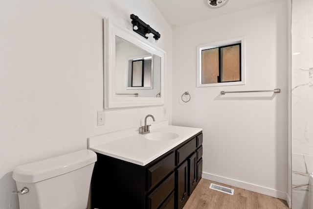 full bath featuring baseboards, visible vents, toilet, wood finished floors, and vanity