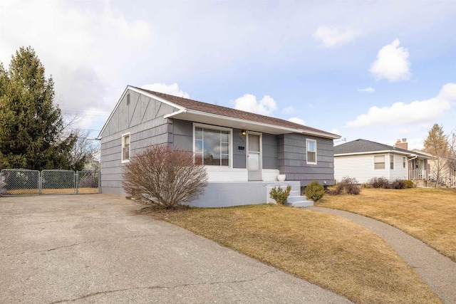 ranch-style house with a gate, fence, and a front lawn