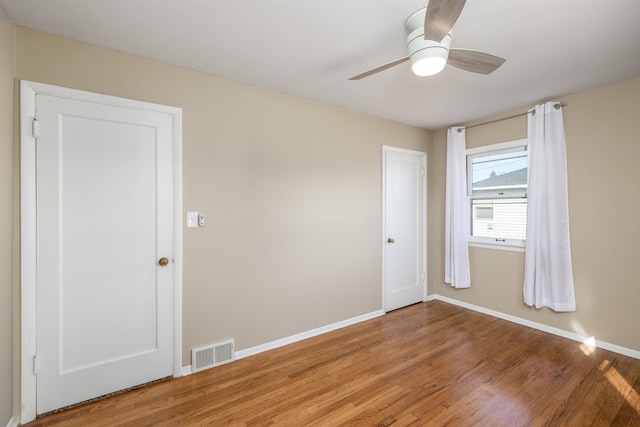 spare room featuring a ceiling fan, baseboards, visible vents, and light wood finished floors