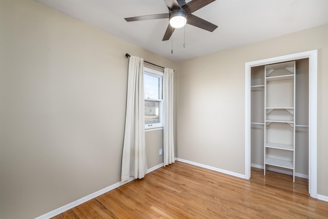 unfurnished bedroom with light wood finished floors, a closet, a ceiling fan, and baseboards