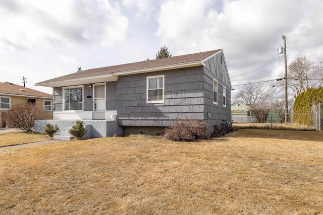 view of front of house with fence and a front lawn