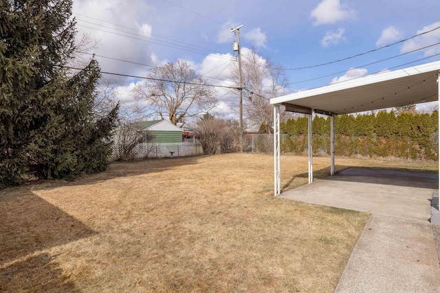 view of yard featuring fence, a carport, and a patio