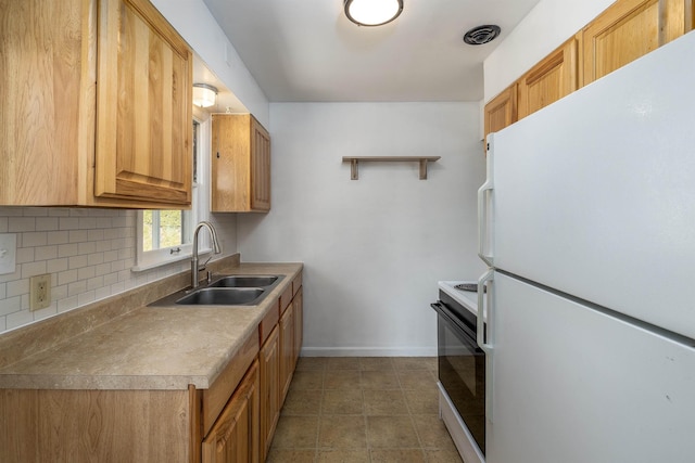 kitchen featuring a sink, visible vents, electric stove, freestanding refrigerator, and decorative backsplash