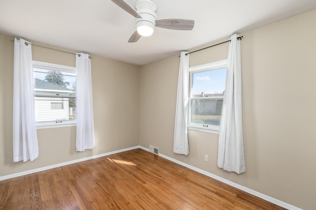 unfurnished room featuring light wood-type flooring, visible vents, ceiling fan, and baseboards