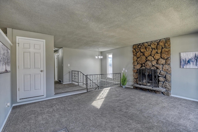 unfurnished living room featuring carpet floors, a chandelier, a fireplace, and baseboards