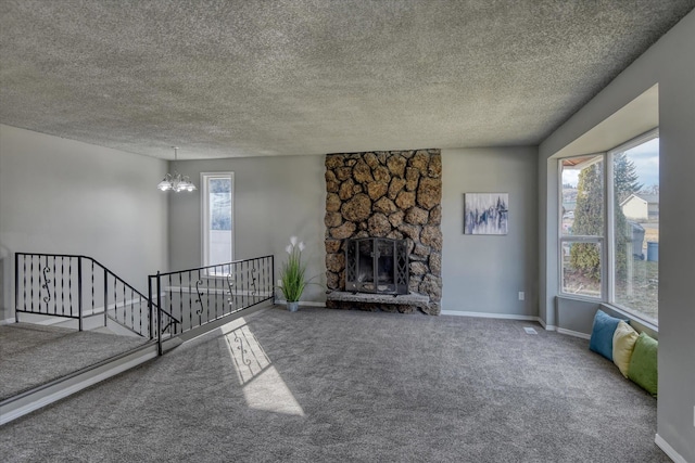 carpeted living area featuring a chandelier, plenty of natural light, a stone fireplace, and baseboards