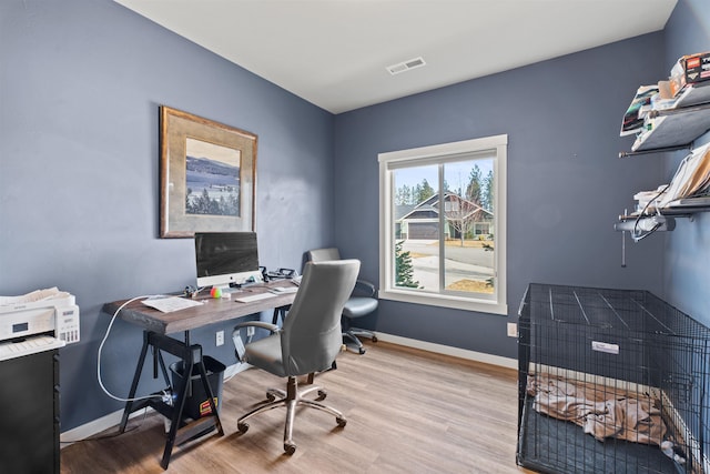 home office featuring baseboards, visible vents, and wood finished floors