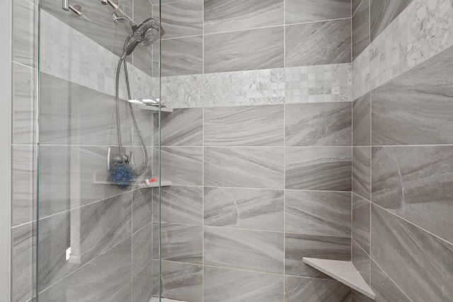 interior details featuring a tile shower