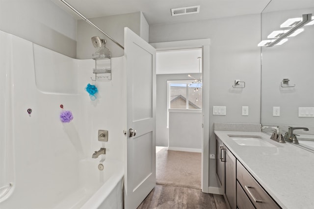 bathroom featuring baseboards, visible vents, wood finished floors, bathtub / shower combination, and vanity