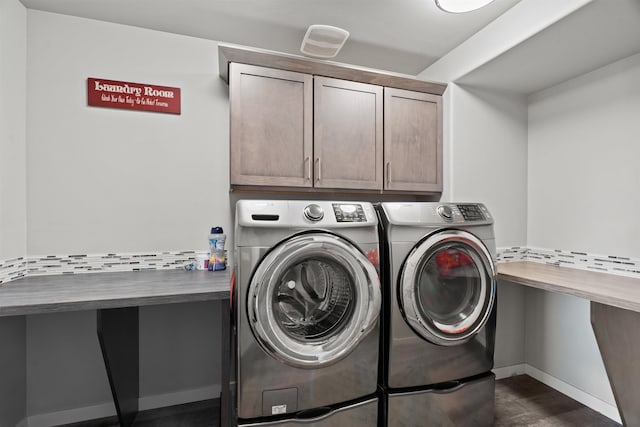 washroom with cabinet space, baseboards, dark wood-style flooring, and washer and dryer