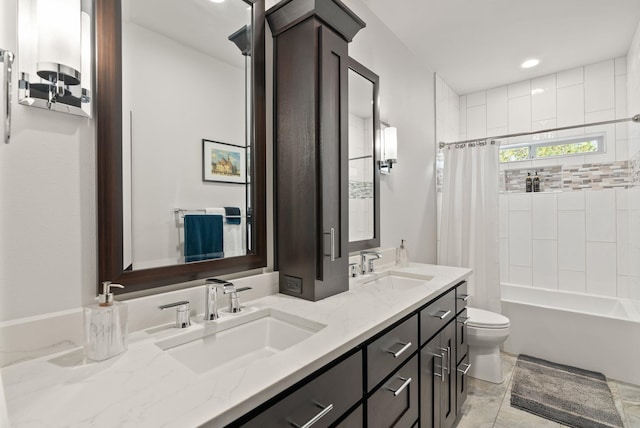 full bath featuring double vanity, shower / bath combo with shower curtain, a sink, and toilet