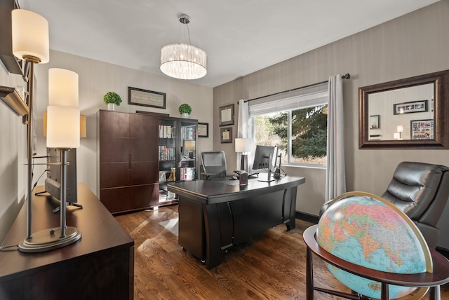 office area with a chandelier and dark wood-type flooring