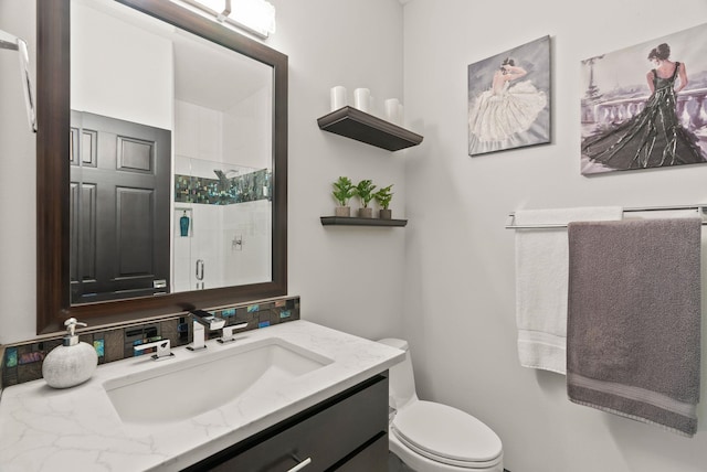 bathroom with a stall shower, vanity, and toilet