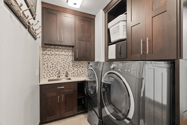 laundry room with cabinet space, light tile patterned flooring, a sink, and independent washer and dryer