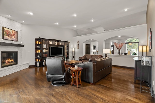 living room with arched walkways, lofted ceiling, recessed lighting, a fireplace, and wood finished floors