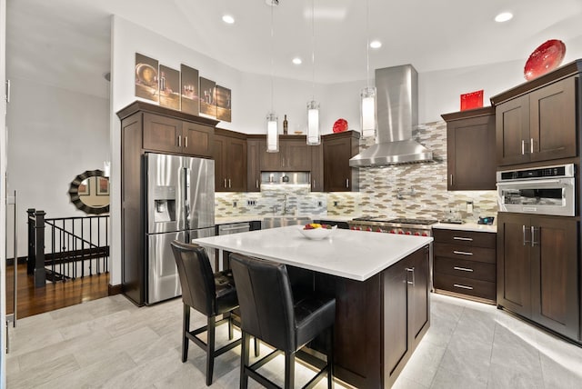 kitchen featuring stainless steel appliances, dark brown cabinets, ventilation hood, light countertops, and a sink