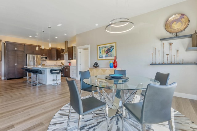 dining area featuring recessed lighting, light wood-style flooring, and baseboards