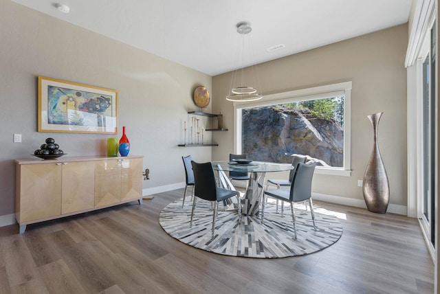 dining room featuring visible vents, baseboards, and wood finished floors