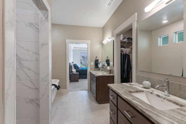 full bathroom with two vanities, visible vents, a sink, and a spacious closet